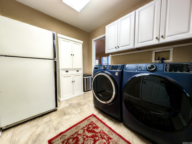 laundry room with washer and dryer and cabinets