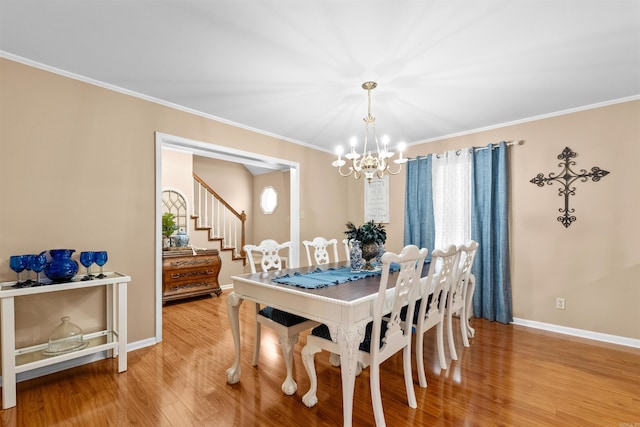 dining area featuring a wealth of natural light, crown molding, hardwood / wood-style flooring, and a notable chandelier