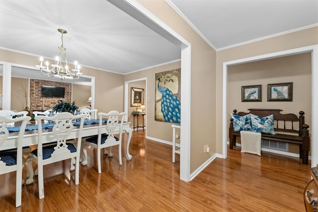 dining space featuring crown molding, a fireplace, wood-type flooring, and a notable chandelier