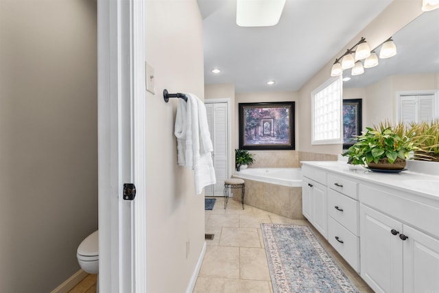 bathroom featuring tiled bath, tile patterned floors, toilet, and vanity