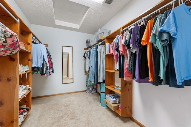 walk in closet with light carpet