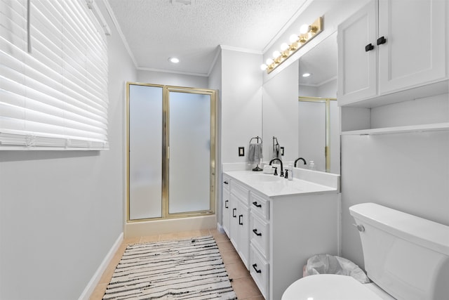 bathroom with a textured ceiling, vanity, toilet, walk in shower, and crown molding