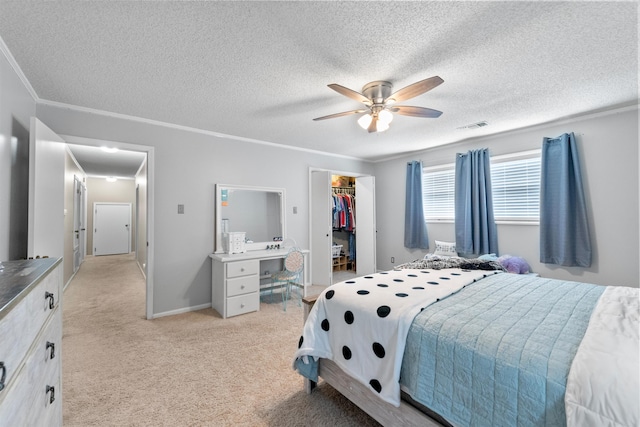 bedroom featuring ceiling fan, a walk in closet, a closet, and ornamental molding