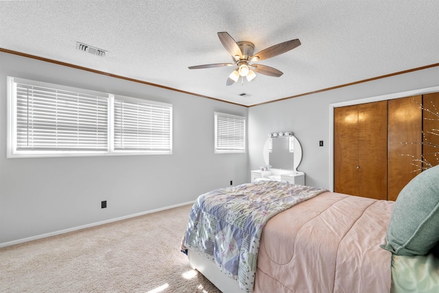 bedroom with ceiling fan, a closet, a textured ceiling, and carpet flooring