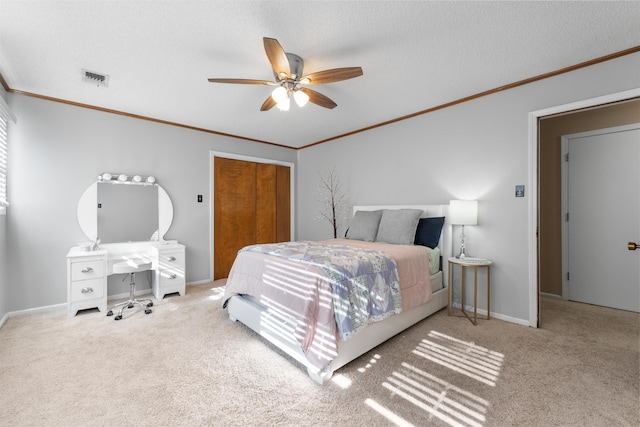 carpeted bedroom featuring ceiling fan, a closet, crown molding, and a textured ceiling