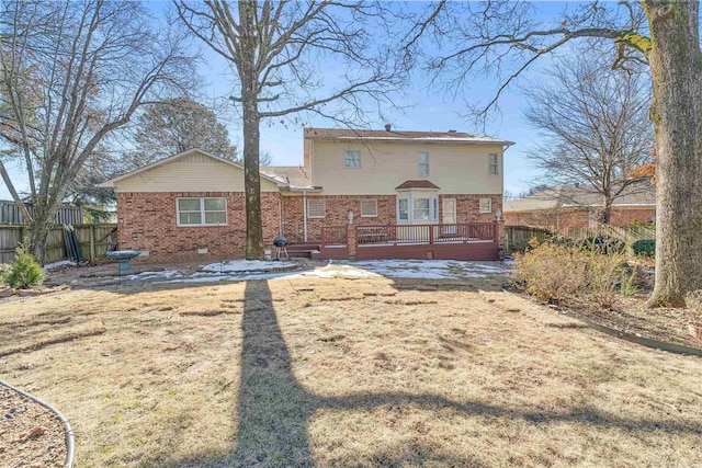 rear view of house with a wooden deck and a lawn