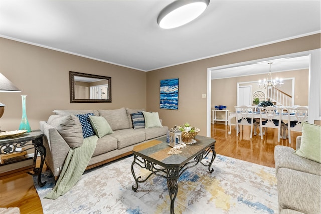 living room with crown molding, hardwood / wood-style floors, and a notable chandelier