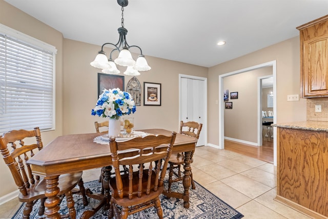 tiled dining space with an inviting chandelier