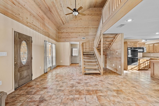 entrance foyer featuring high vaulted ceiling, ceiling fan, wood ceiling, and wood walls