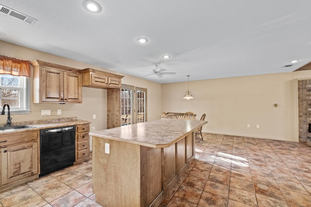 kitchen featuring ceiling fan, black dishwasher, hanging light fixtures, a kitchen island, and sink