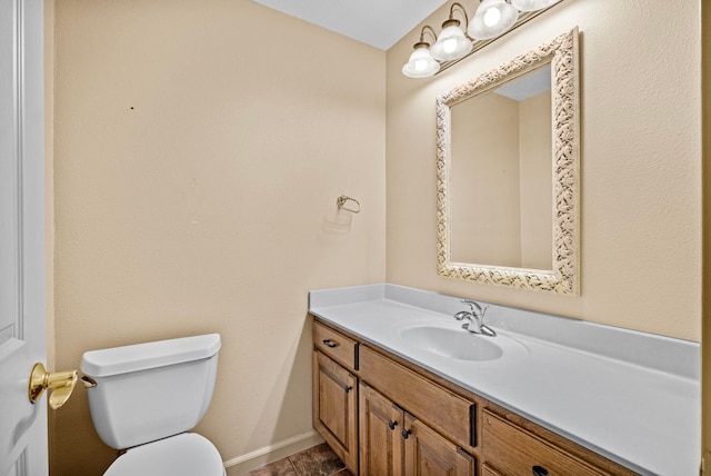 bathroom with toilet, vanity, and tile patterned floors