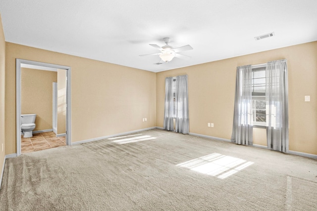 spare room featuring light carpet and ceiling fan