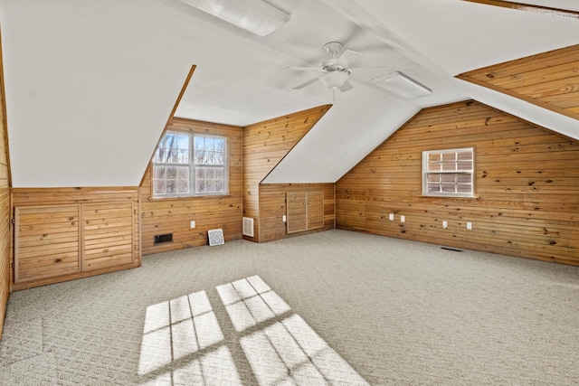 bonus room with ceiling fan, carpet, lofted ceiling, and wood walls