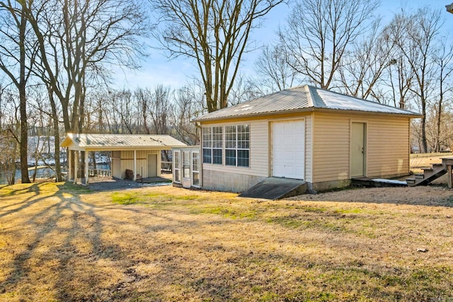 back of house featuring a garage, an outbuilding, and a yard