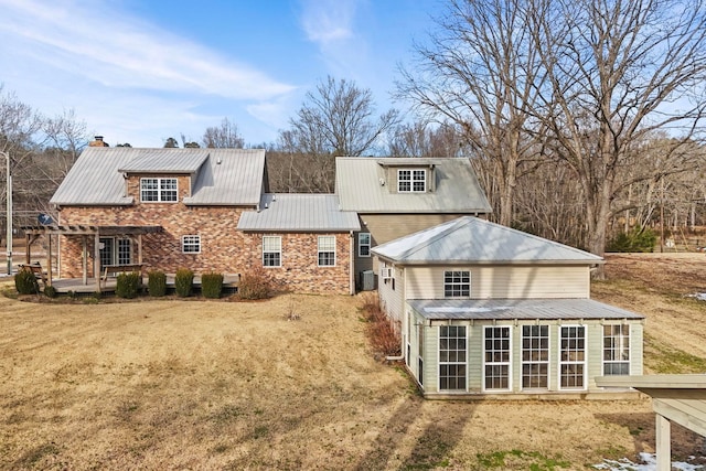 back of property with a sunroom, central AC unit, a yard, and a pergola