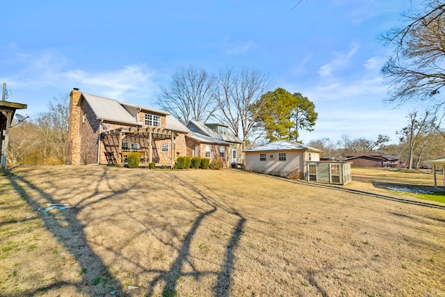 back of house with a yard and an outdoor structure