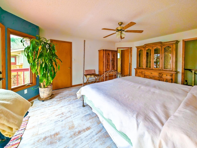 bedroom with ceiling fan, a textured ceiling, and light wood-type flooring