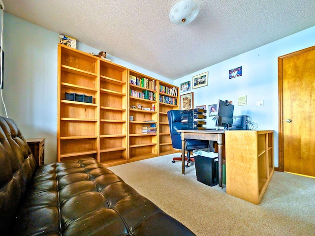 carpeted home office featuring a textured ceiling