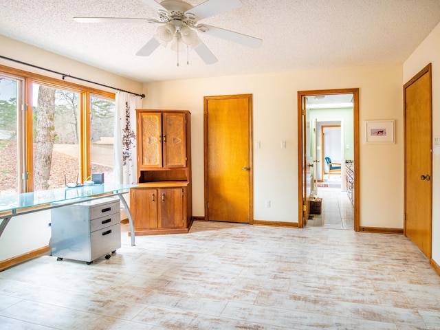 interior space with ceiling fan and a textured ceiling