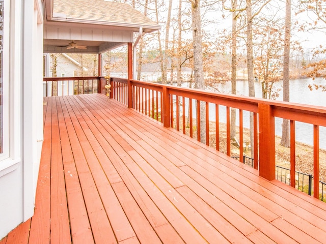 deck with a water view and ceiling fan