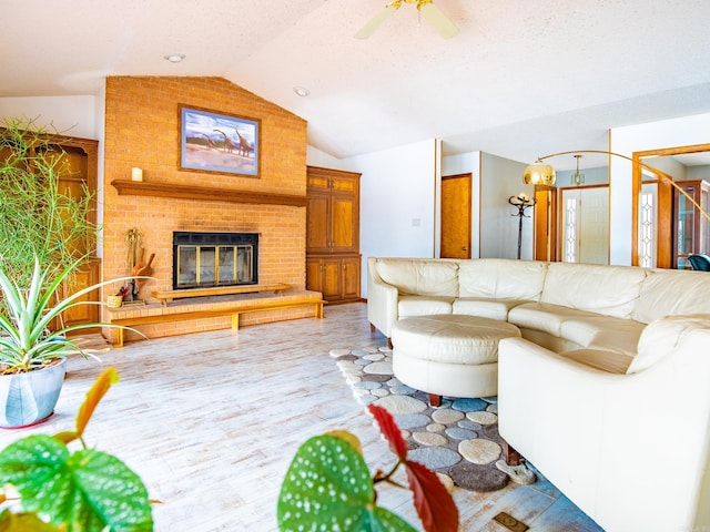 living room featuring wood-type flooring, a brick fireplace, lofted ceiling, and ceiling fan