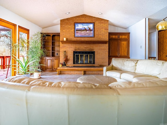 unfurnished living room featuring hardwood / wood-style floors, vaulted ceiling, a brick fireplace, and a textured ceiling