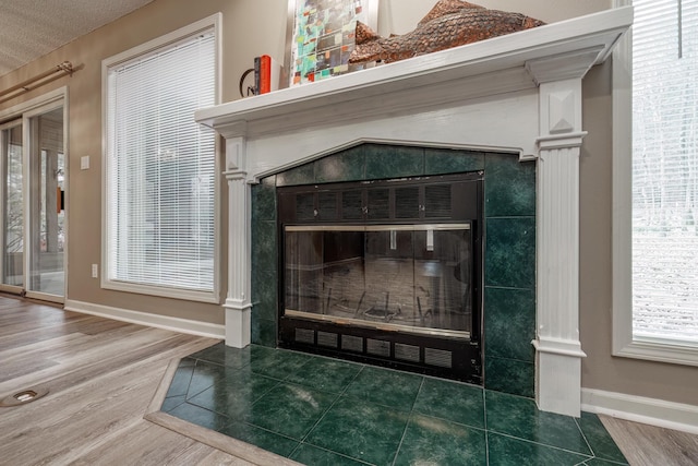 interior details featuring wood-type flooring and a tile fireplace