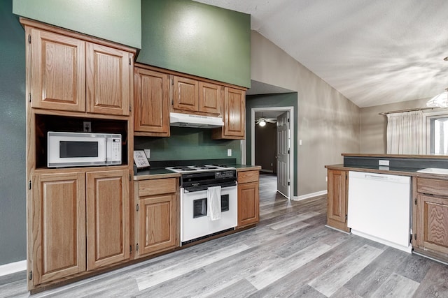 kitchen with vaulted ceiling, ceiling fan, light wood-type flooring, and white appliances