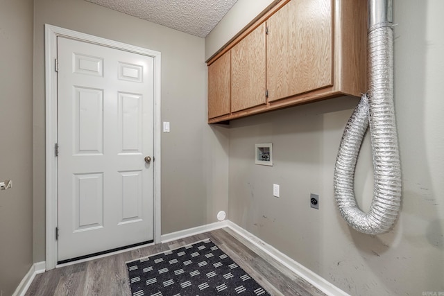 clothes washing area featuring a textured ceiling, cabinets, dark wood-type flooring, electric dryer hookup, and hookup for a washing machine