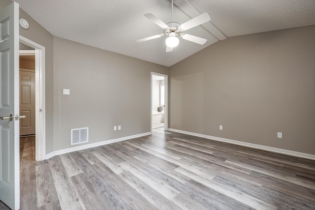 unfurnished room with a textured ceiling, ceiling fan, lofted ceiling, and light hardwood / wood-style floors