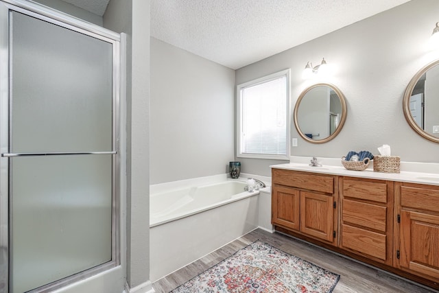 bathroom featuring vanity, plus walk in shower, a textured ceiling, and hardwood / wood-style flooring