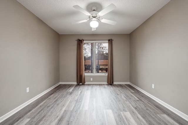 unfurnished room featuring ceiling fan, light wood-type flooring, and a textured ceiling