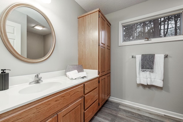 bathroom featuring wood-type flooring, a textured ceiling, and vanity