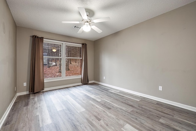 empty room featuring ceiling fan, a textured ceiling, and light wood-type flooring