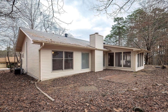 back of property with central air condition unit and a sunroom