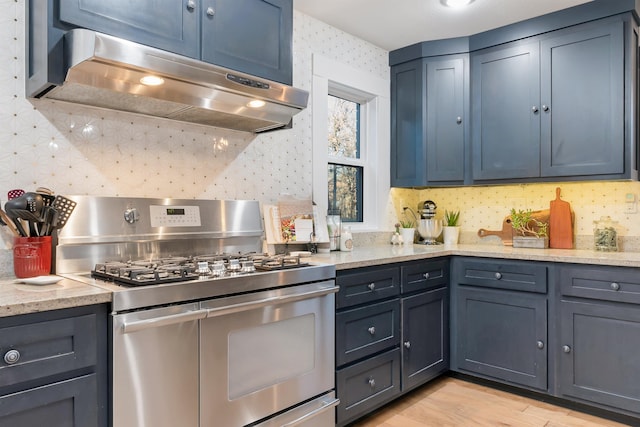 kitchen featuring exhaust hood, light hardwood / wood-style floors, tasteful backsplash, range with two ovens, and light stone countertops