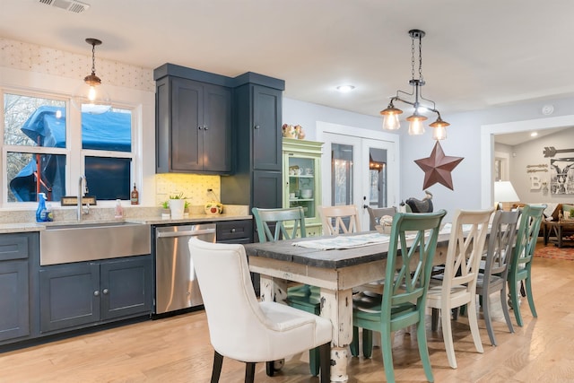 dining space featuring light hardwood / wood-style flooring, french doors, and sink