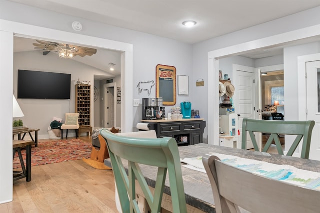 dining room with light wood-type flooring, ceiling fan, and lofted ceiling