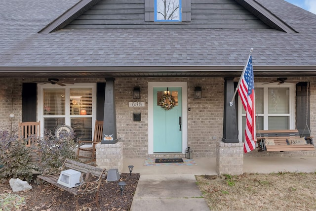 view of exterior entry featuring ceiling fan and a porch