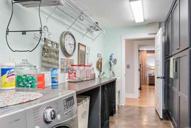 laundry room featuring cabinets, a textured ceiling, and independent washer and dryer