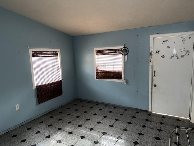 unfurnished room with lofted ceiling