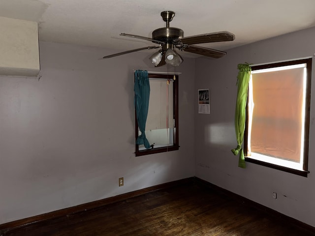 unfurnished room featuring dark wood-type flooring and ceiling fan