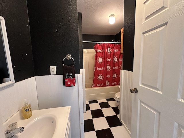 full bathroom featuring toilet, shower / bathtub combination with curtain, and sink