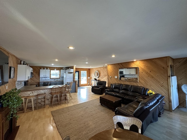 living room with wood walls and light hardwood / wood-style floors