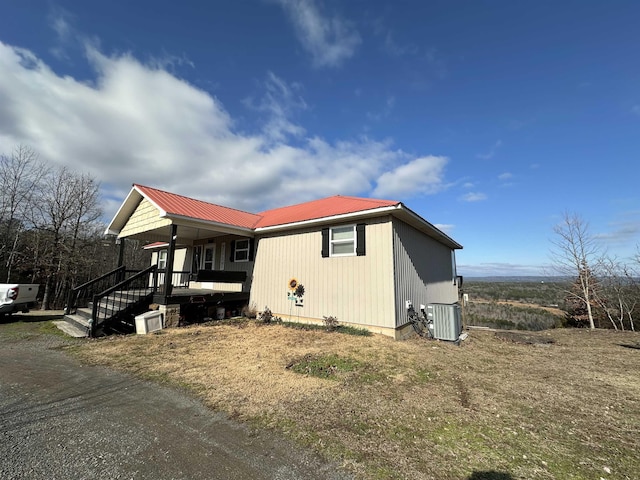 view of side of property featuring a porch and cooling unit