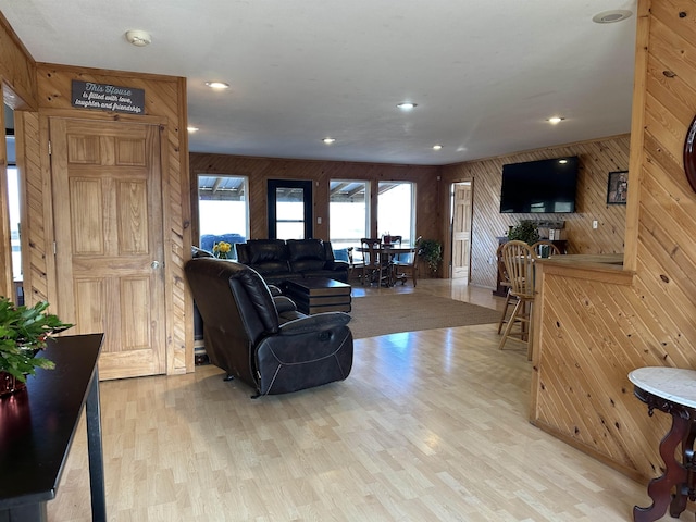 living room featuring light hardwood / wood-style floors and wooden walls