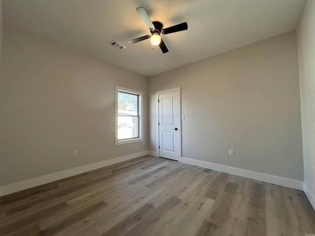 empty room with ceiling fan and hardwood / wood-style flooring