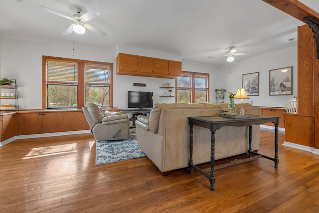 living room featuring ceiling fan, wooden walls, and hardwood / wood-style floors