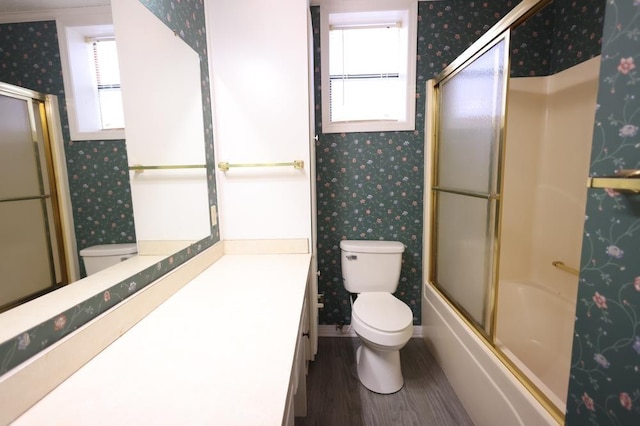 full bathroom featuring toilet, enclosed tub / shower combo, hardwood / wood-style flooring, and vanity