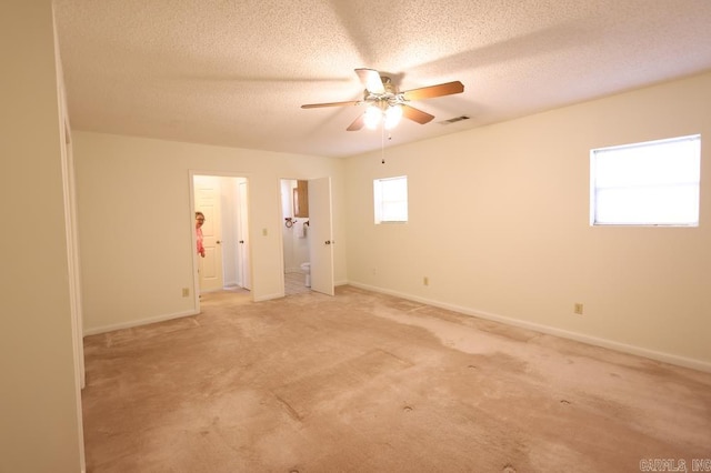 unfurnished room with ceiling fan, light colored carpet, and a textured ceiling